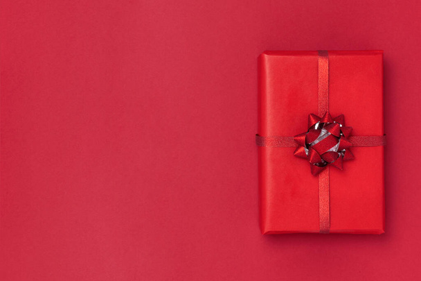 New Year and Christmas composition. Gift box on red background. Top view, flat lay, copy space - Φωτογραφία, εικόνα