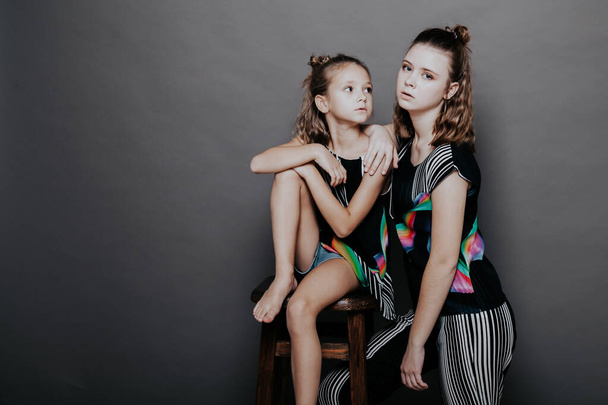 two fashionable girls sisters in beautiful clothes portrait - Fotó, kép