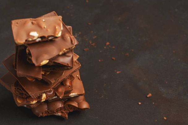 Pile of the chunks of broken different chocolate bars with nuts, whisper, bubble - Фото, зображення