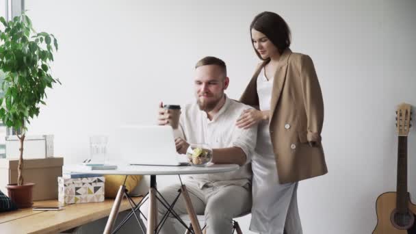 Business man and woman working together. Woman brings coffee to her colleague - Imágenes, Vídeo