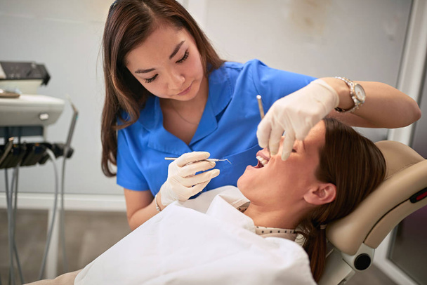 Female dentist in clinic working with patient - 写真・画像