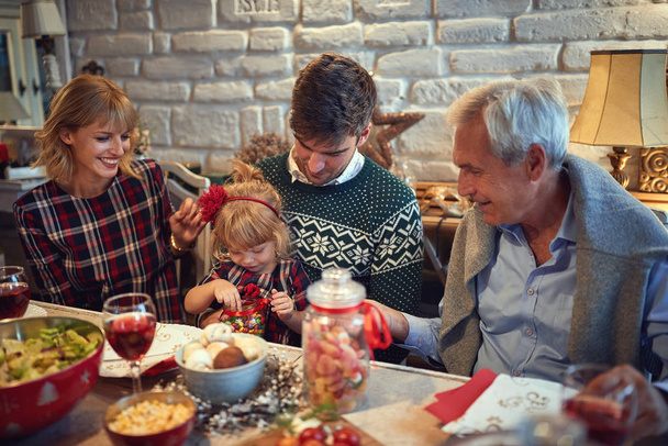 Holčička vybírá sladkosti u vánočního stolu - Fotografie, Obrázek
