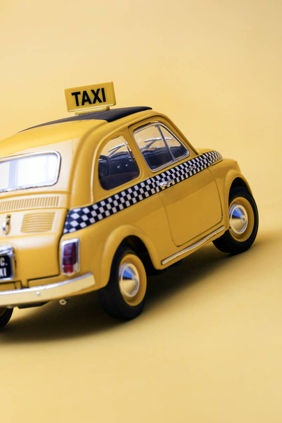 Žlutá retro hračka taxi na žlutém pozadí - Fotografie, Obrázek