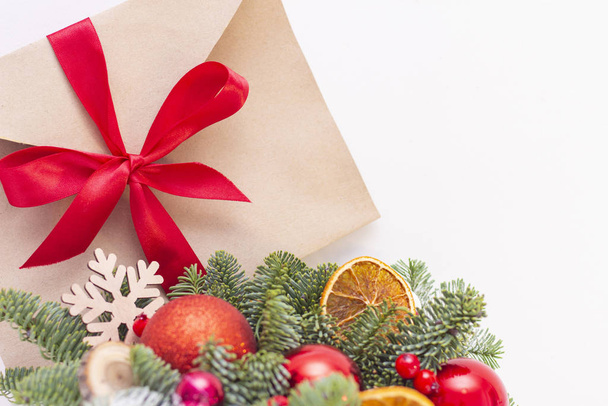 Christmas composition. Christmas decorations, fir branches, envelope with a red ribbon. copy space - Foto, Imagem