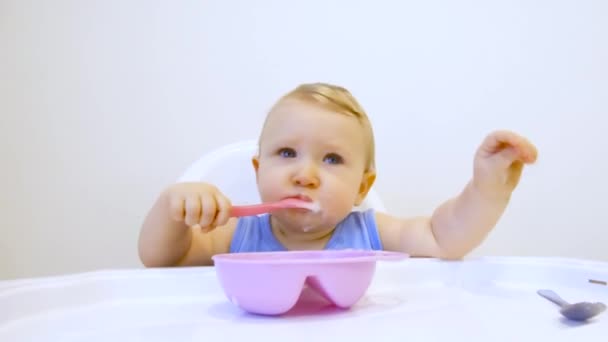 Zum ersten Mal in seinem Leben isst ein Kind selbst Brei. das Kind isst zum ersten Mal allein - Filmmaterial, Video