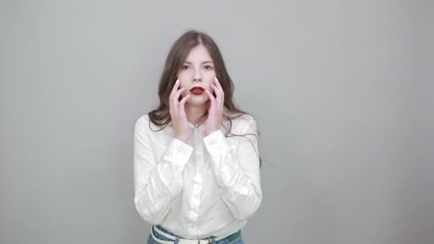 Γοητευτική καυκάσιος νεαρή γυναίκα στη μόδα λευκό πουκάμισο απομονωμένο σε γκρι τοίχο - Πλάνα, βίντεο