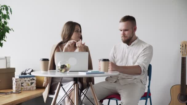 Two young people are discussing and preparing the contract. It is a business meeting. Man and woman are sitting in the cafe at the table during break. - Filmmaterial, Video