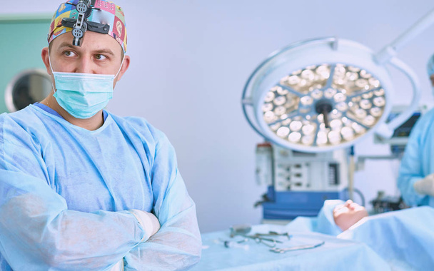 Verschillende artsen rondom patiënt op operatietafel tijdens t - Foto, afbeelding