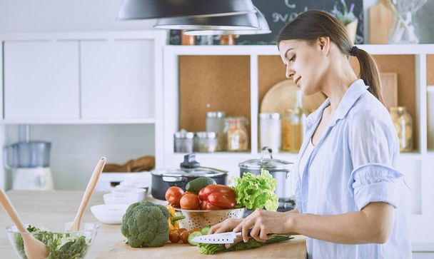 A young woman prepares food in the kitchen. Healthy food - vege - Foto, imagen