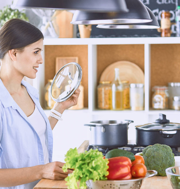 Eine junge Frau bereitet in der Küche Essen zu. gesunde Ernährung - vegetarisch - Foto, Bild