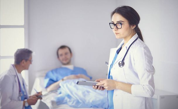 Orvos ellenőrzi a szívverés a beteg az ágyban sztetoszkóp - Fotó, kép