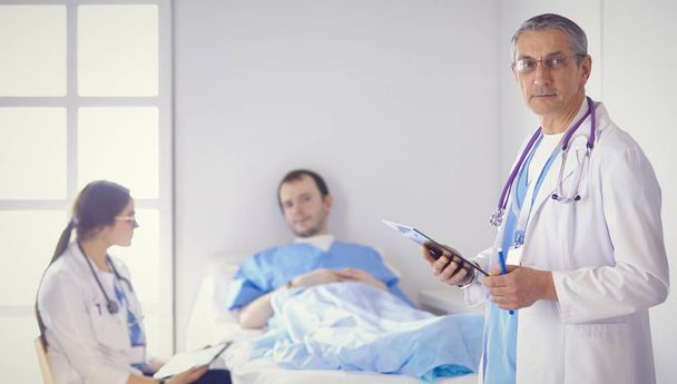 Orvos ellenőrzi a szívverés a beteg az ágyban sztetoszkóp - Fotó, kép
