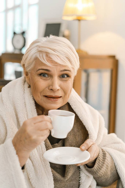 Grey-haired Old Woman Drinking Hot Tea And Relaxing At Home - Valokuva, kuva