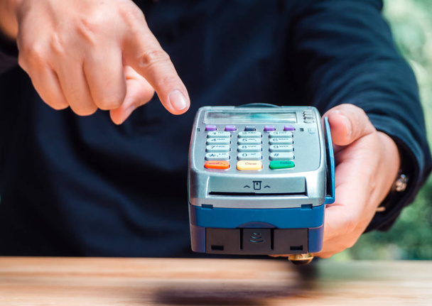 Male's hand with payment credit card through terminal for shoppi - Photo, Image