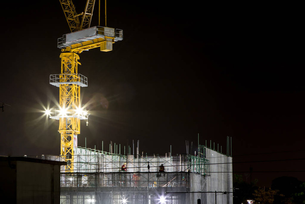 Crane and spotlight on buildings under construction - Photo, Image