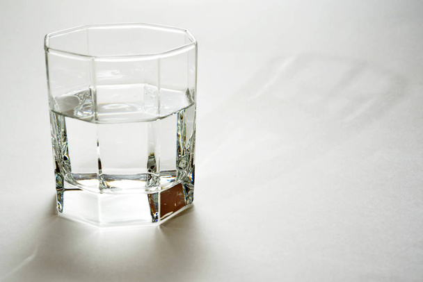 faceted glass with clear water or liquid - Foto, afbeelding