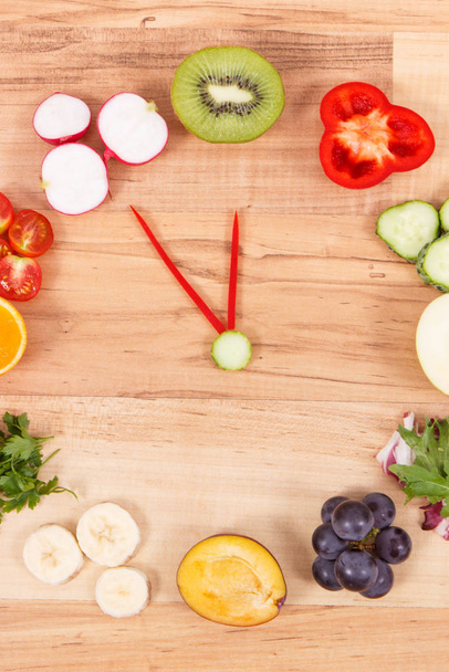 Reloj hecho de frutas y verduras que contienen minerales, tiempo para resoluciones de concepto de nutrición saludable
 - Foto, Imagen