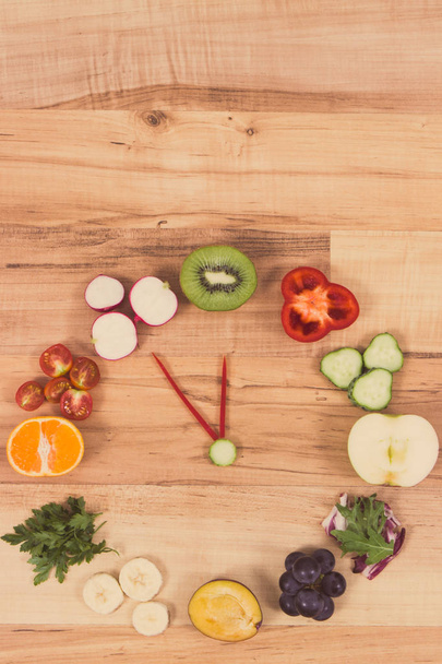 Orologio fatto di frutta e verdura contenente minerali, tempo per risoluzioni di concetto nutrizionale sano
 - Foto, immagini