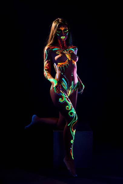 Female with UV color pattern bodyart in the dark - Φωτογραφία, εικόνα