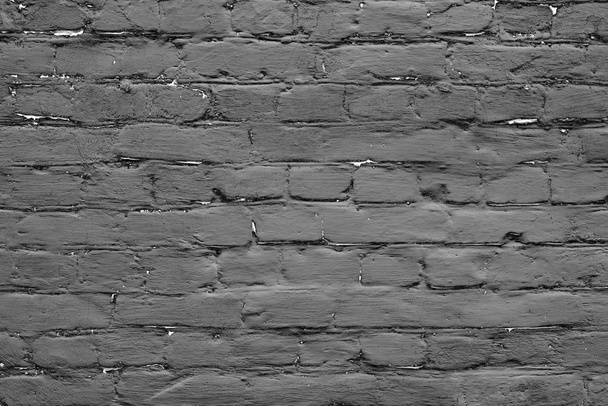 Textuur van een bakstenen muur met scheuren en krassen die als achtergrond kunnen worden gebruikt - Foto, afbeelding