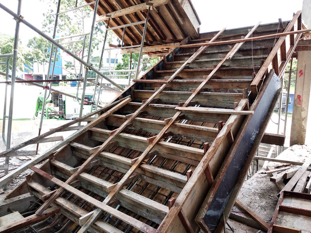 Kuala Lumpur, Malajsie - 12. května 2018: Betonové schodiště ve výstavbě na staveništi. Dřevěné bednění zhotovené stavebními dělníky jako plíseň na schodišti. - Fotografie, Obrázek