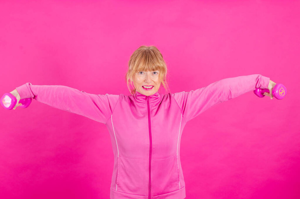 gym dumbbell woman doing sport in color background - Foto, Imagem