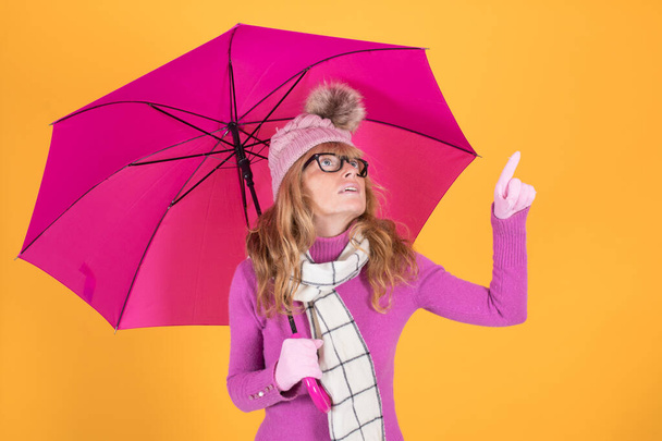 adult woman sheltered with umbrella and colored background - Photo, image