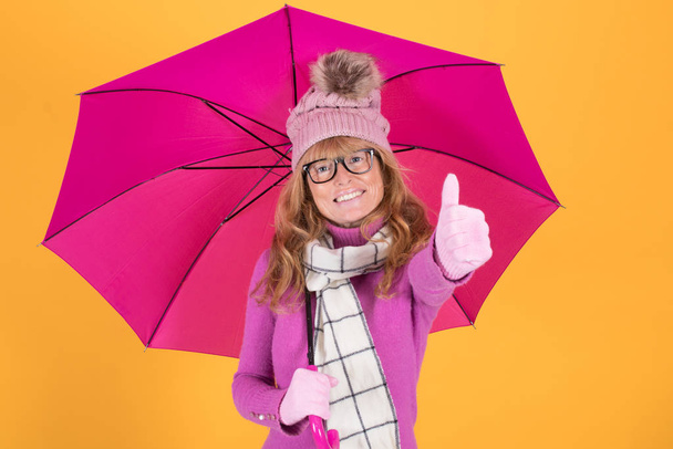 mujer adulta con ropa de abrigo y paraguas
 - Foto, Imagen