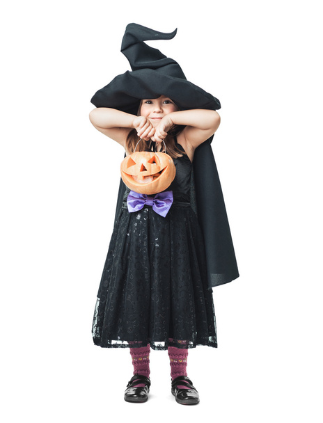 little witch shows pumpkins - Foto, afbeelding