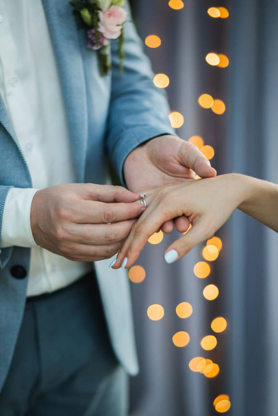 A férfi jegygyűrűt visel a nő kezén, közelről. A szerelem szimbóluma  - Fotó, kép
