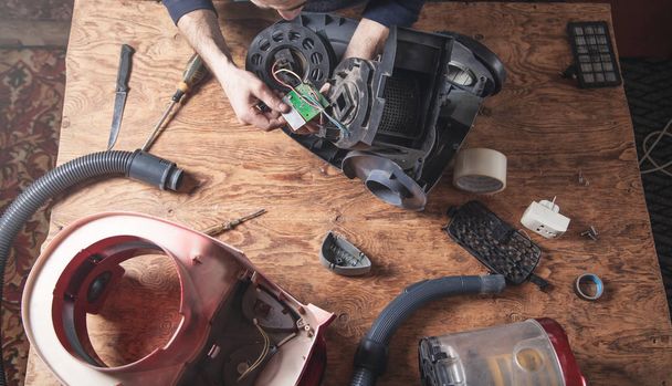 Man repairs of vacuum cleaner. Repairing - Photo, Image