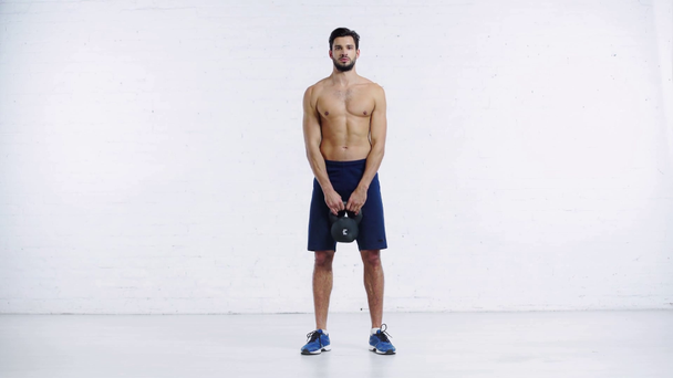 Sportler trainiert mit Gewicht auf weißem Hintergrund - Filmmaterial, Video
