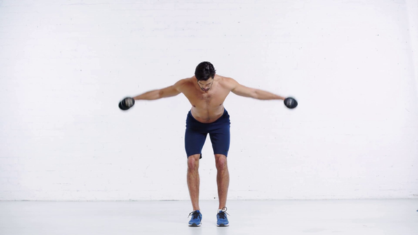 Sportler beim Training mit Kurzhanteln auf weißem Hintergrund - Filmmaterial, Video