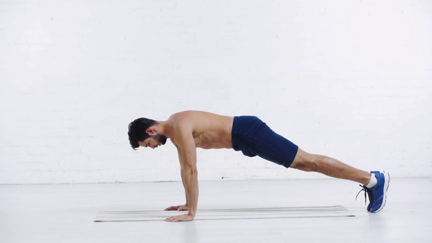 sportsman doing push ups on white background - Video, Çekim