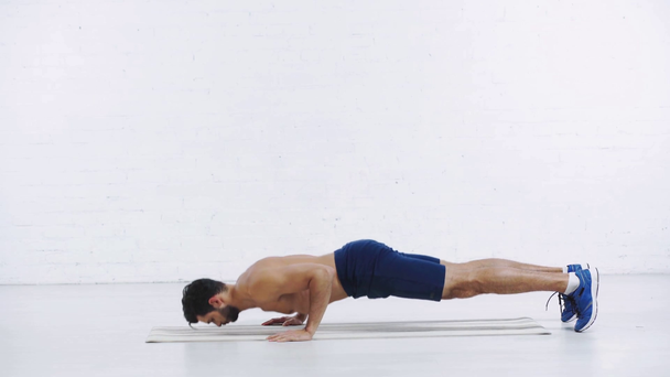 sportsman doing push ups on white background - Video, Çekim