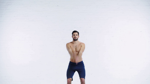 sporter doet handen rotatie op witte achtergrond - Video