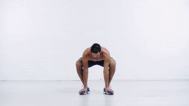 sportsman squatting from sit position on white background - Felvétel, videó