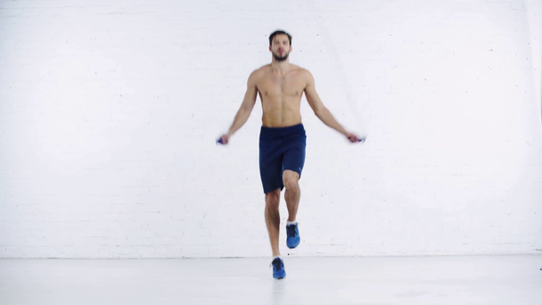 desportista exercitando com corda de salto no fundo branco
 - Filmagem, Vídeo