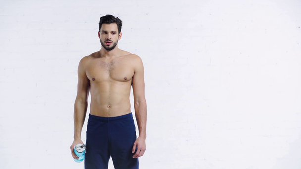 εξαντλημένος αθλητής πόσιμο νερό σε λευκό φόντο - Πλάνα, βίντεο