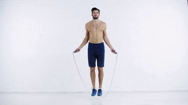 sportsman exercising with jump rope on white background - Πλάνα, βίντεο