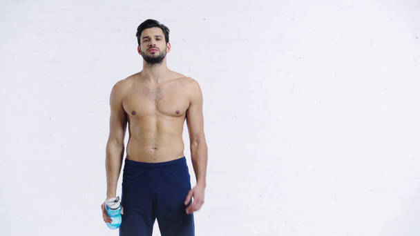 Müder Sportler trinkt Wasser auf weißem Hintergrund - Filmmaterial, Video