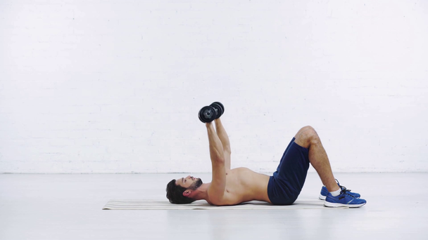 deportista haciendo ejercicio con mancuernas sobre fondo blanco
 - Metraje, vídeo