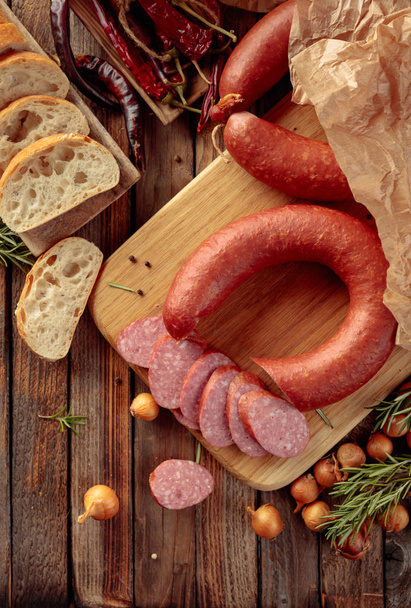 Smoked sausage with bread and spices on a old wooden table. - 写真・画像