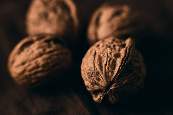 A closeup selective focus shot of delicious fresh walnuts on a wooden surface - Zdjęcie, obraz
