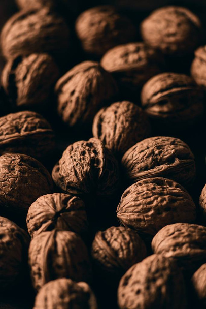 A closeup vertical shot of delicious fresh walnuts on a wooden surface - Valokuva, kuva