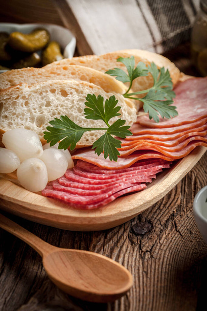 Tapas with sliced sausage, salami, olives, marinated onions, cuc - Photo, Image