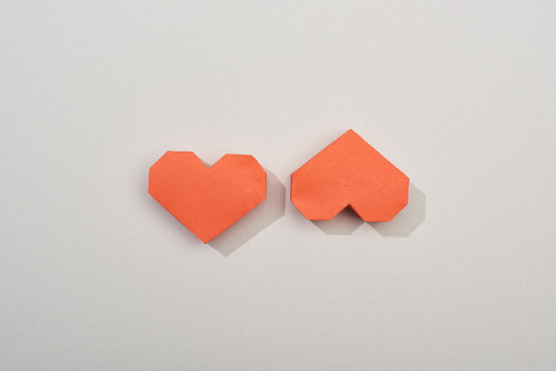 Top view of two red paper hearts on grey background - Fotó, kép