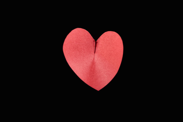 Top view of red paper in heart shape isolated on black - Foto, immagini