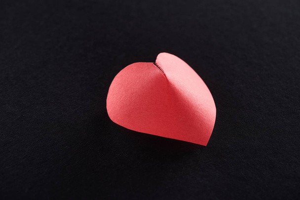 Red paper in heart shape isolated on black - Photo, Image