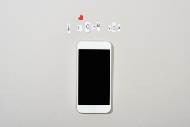 Top view of smartphone with blank screen and i love you lettering on grey background - Photo, Image